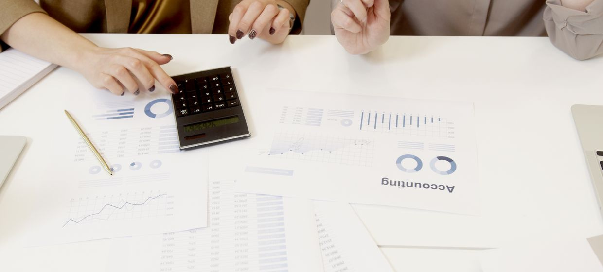laptop showing accounting spreadsheet on a desk with calculator