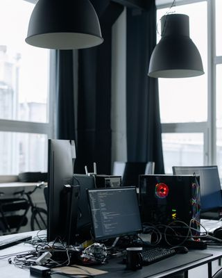 two computer monitors with code on a desk