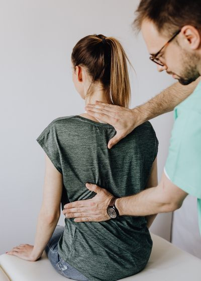 chiropractor checking back of faceless patient