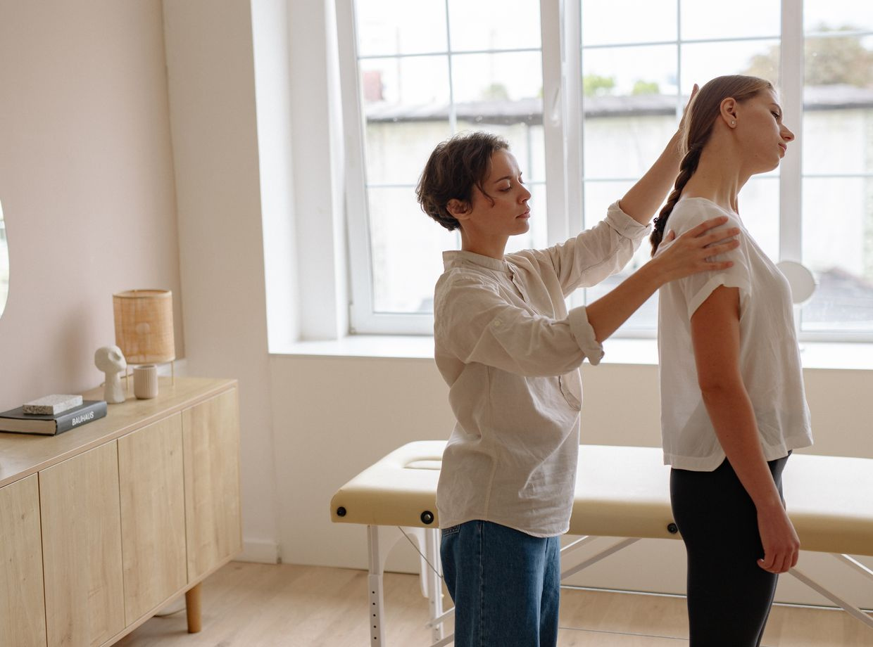 chiropractor adjusts patient posture in clinic
