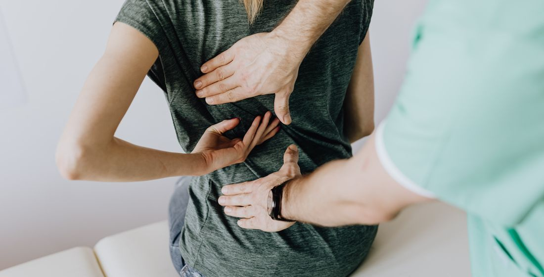 crop chiropractor checking back of faceless patient