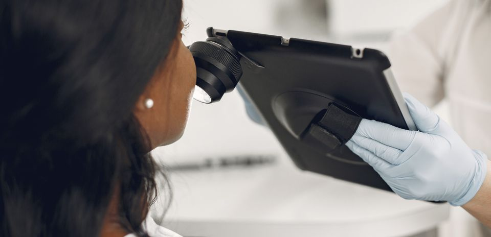dermatologist examining skin with digital dermatoscope