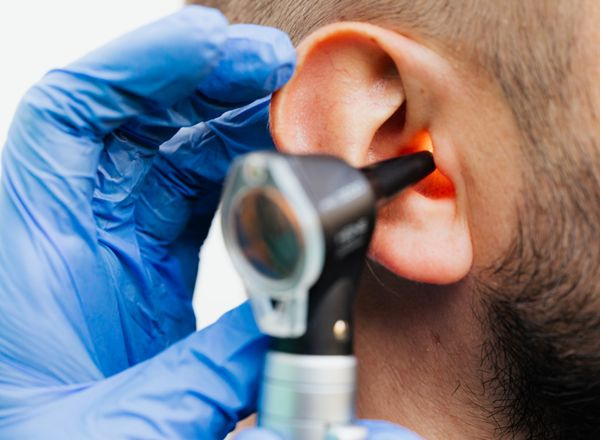 doctor using otoscope examining patient ear