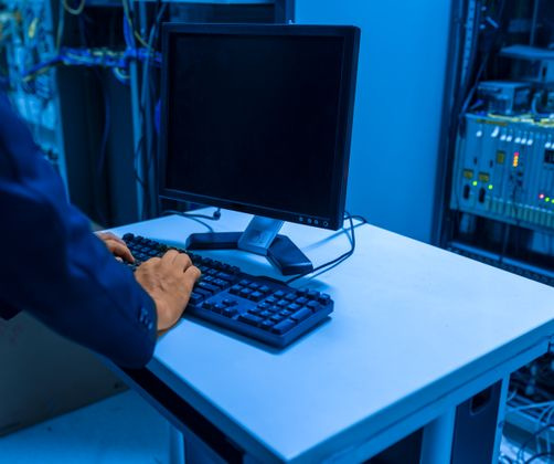 IT technician at a server rack in a data room