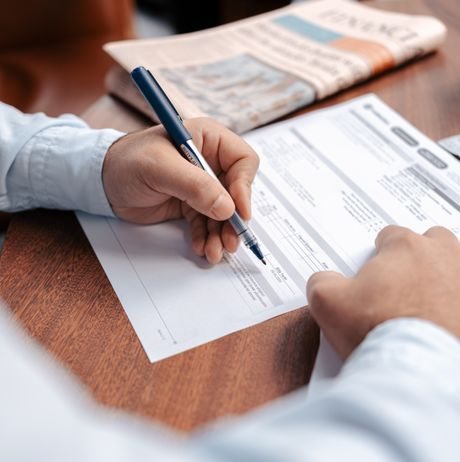 signing a contract with a pen at an office desk