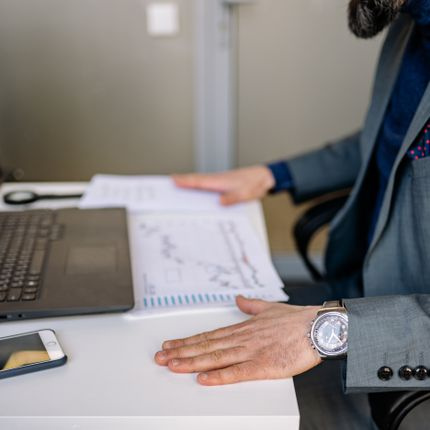 laptop with charts and notebook on desk