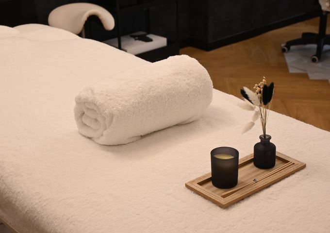 spa massage table with rolled towel and candle