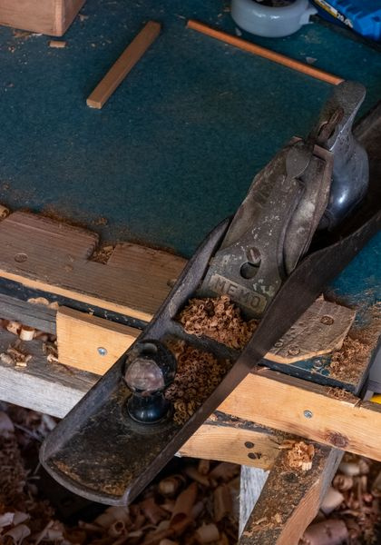 hand plane and wood shavings on a workbench