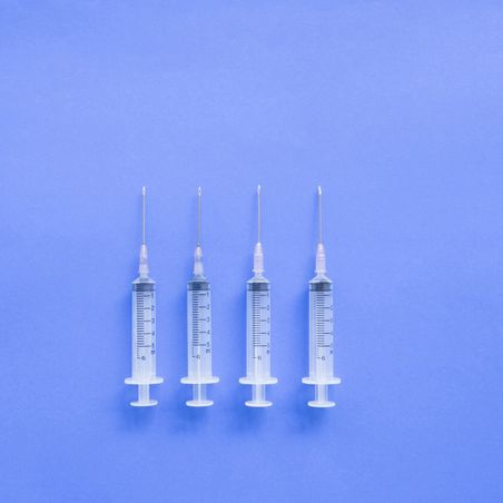 medical syringes flat lay on blue surface