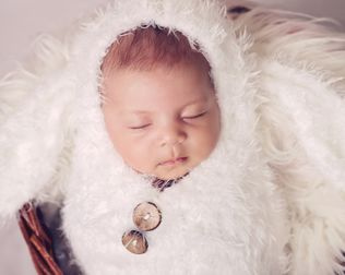 newborn baby sleeping in a basket