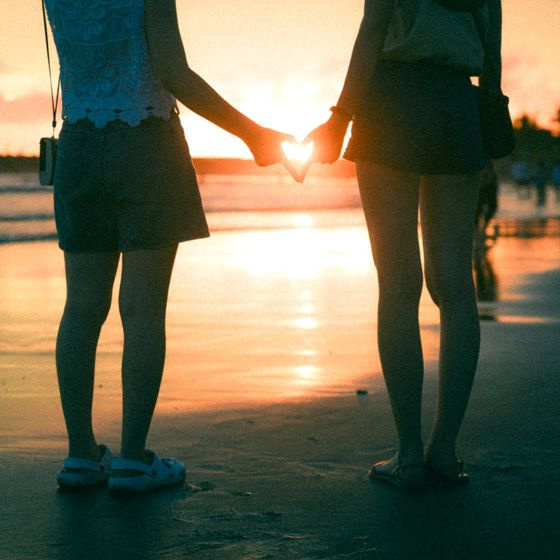 family at the beach at sunset holding hands