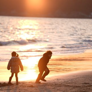 family on a beach at sunset golden hour