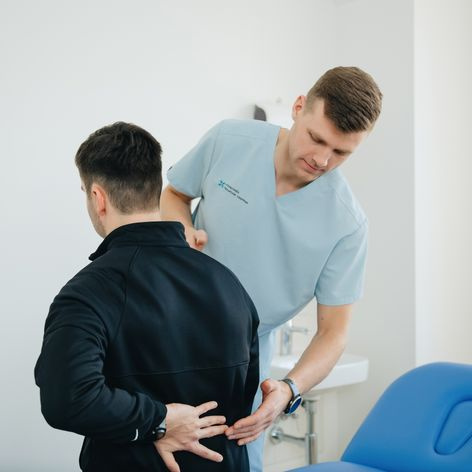 physiotherapist treating patient back pain in clinic