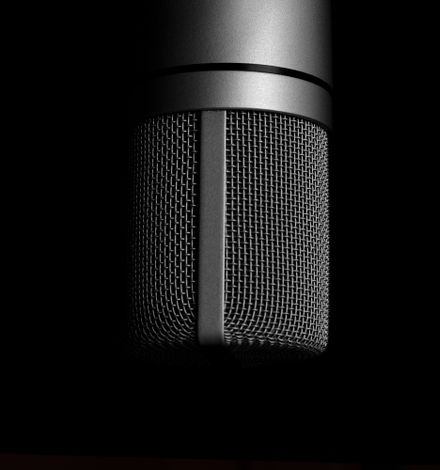 vintage microphone on stand against dark curtain
