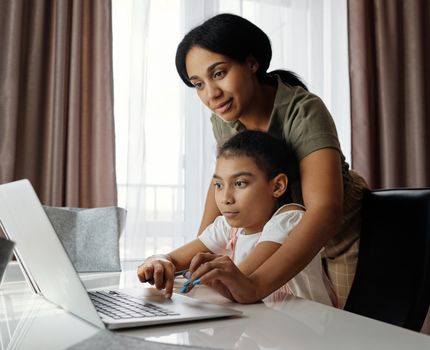 kid at laptop listening to teacher