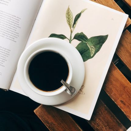 coffee cup and open notebook on rustic wooden table top view